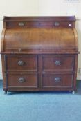 A C19th mahogany cylinder bureau with fold down work surface over four drawers, raised on brass