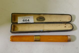 A Victorian amber cigar holder with 9ct gold mounts, cased with label Comoys London, 14cm long, AF