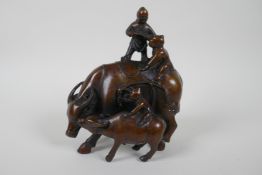 A Chinese filled bronze figure group of children playing on a buffalo, 18cm high