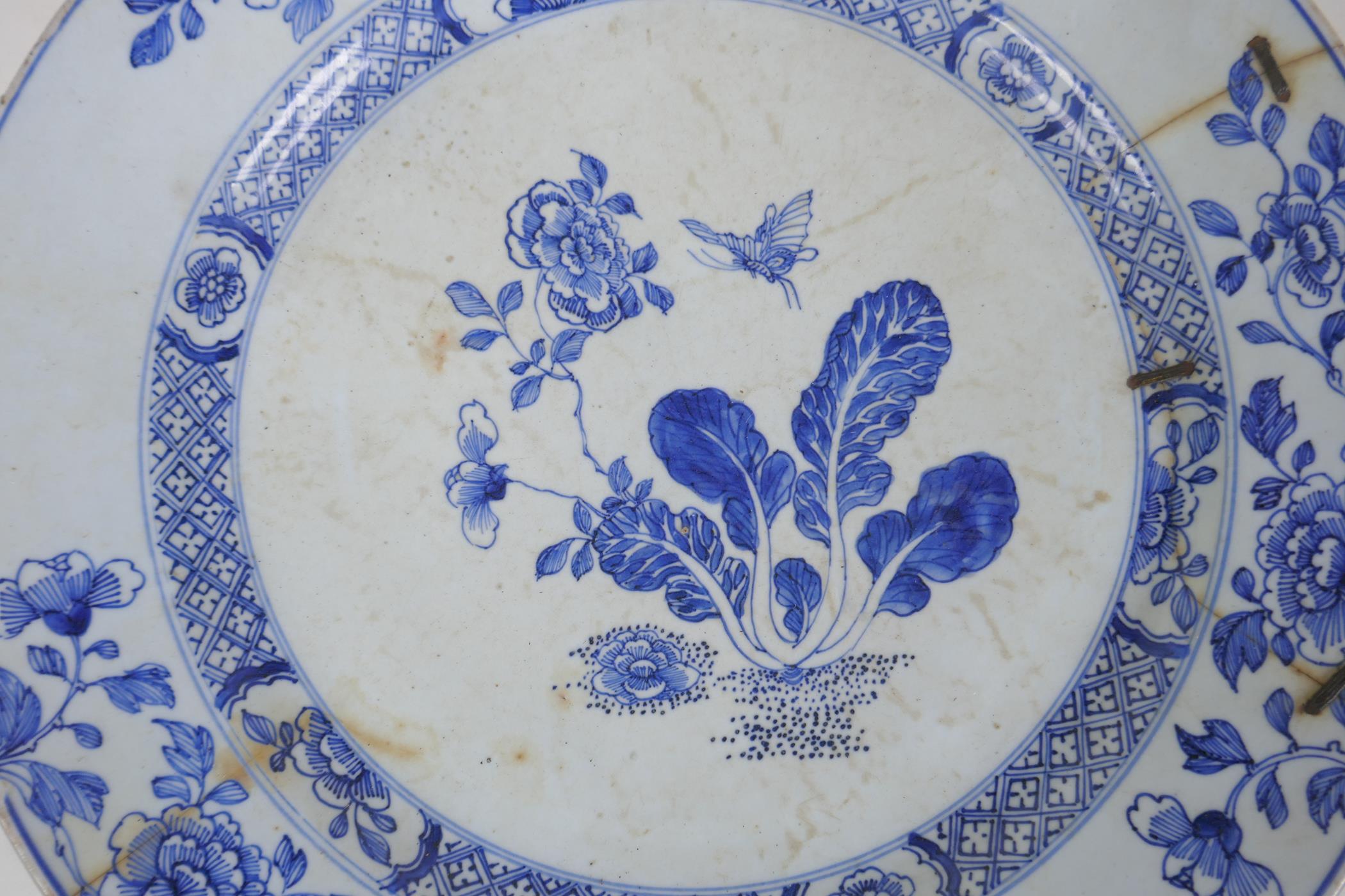 A C19th Delft tin glazed charger decorated with flowers and butterflies, AF, historic repair, 31cm - Image 2 of 4
