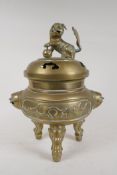 A Chinese bronze censer and cover on tripod supports, with twin mask handles, kylin knop and