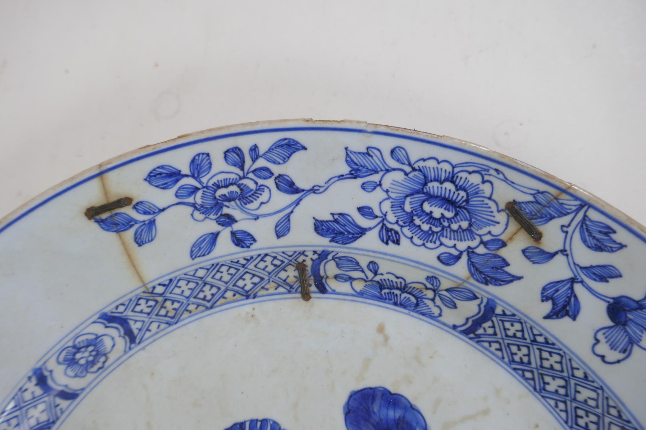 A C19th Delft tin glazed charger decorated with flowers and butterflies, AF, historic repair, 31cm - Image 3 of 4