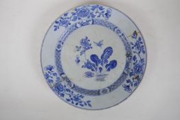 A C19th Delft tin glazed charger decorated with flowers and butterflies, AF, historic repair, 31cm