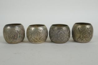 Four Iranian white metal napkin rings with chased floral pattern decoration, 4.5cm diameter