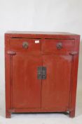 A Chinese red lacquered wood cabinet with two drawers over two doors, 74 x 50cm, 87cm high