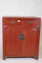 A Chinese red lacquered wood cabinet with two drawers over two doors, 74 x 50cm, 87cm high