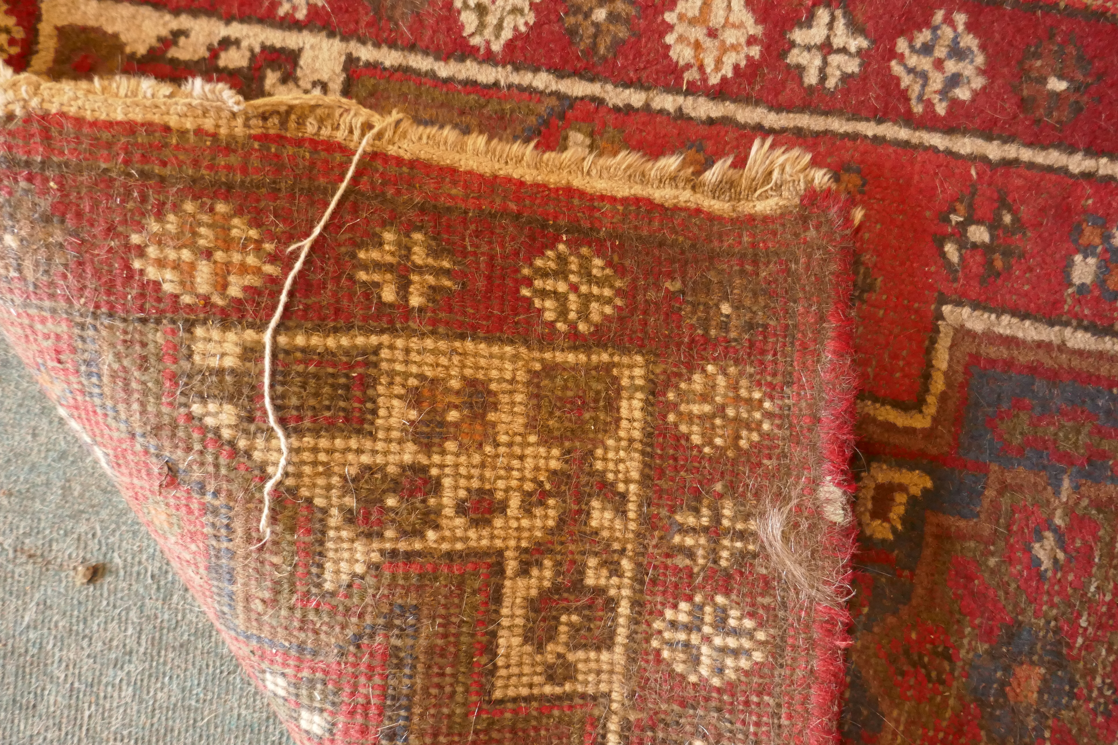 A Persian red ground wool rug with a geometric medallion design, 66 x 122cm - Image 3 of 3