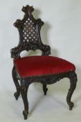 A C19th Chippendale style walnut hall chair, with carved and pierced trellis back, raised on