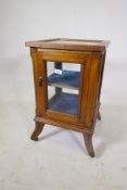 A small walnut vitrine with single door, raised on shaped supports with castors, 39 x 39 x 66cm