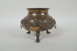 An antique Chinese silver censer on tripod paw feet, with two lion mask handles and repousse