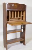 An Arts and Crafts oak bureau, with fall front and fitted interior over two open shelves, 61 x 22