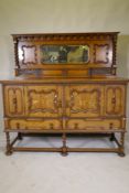 An early C20th oak Jacobean style mirror back sideboard, with two cupboards opening to reveal