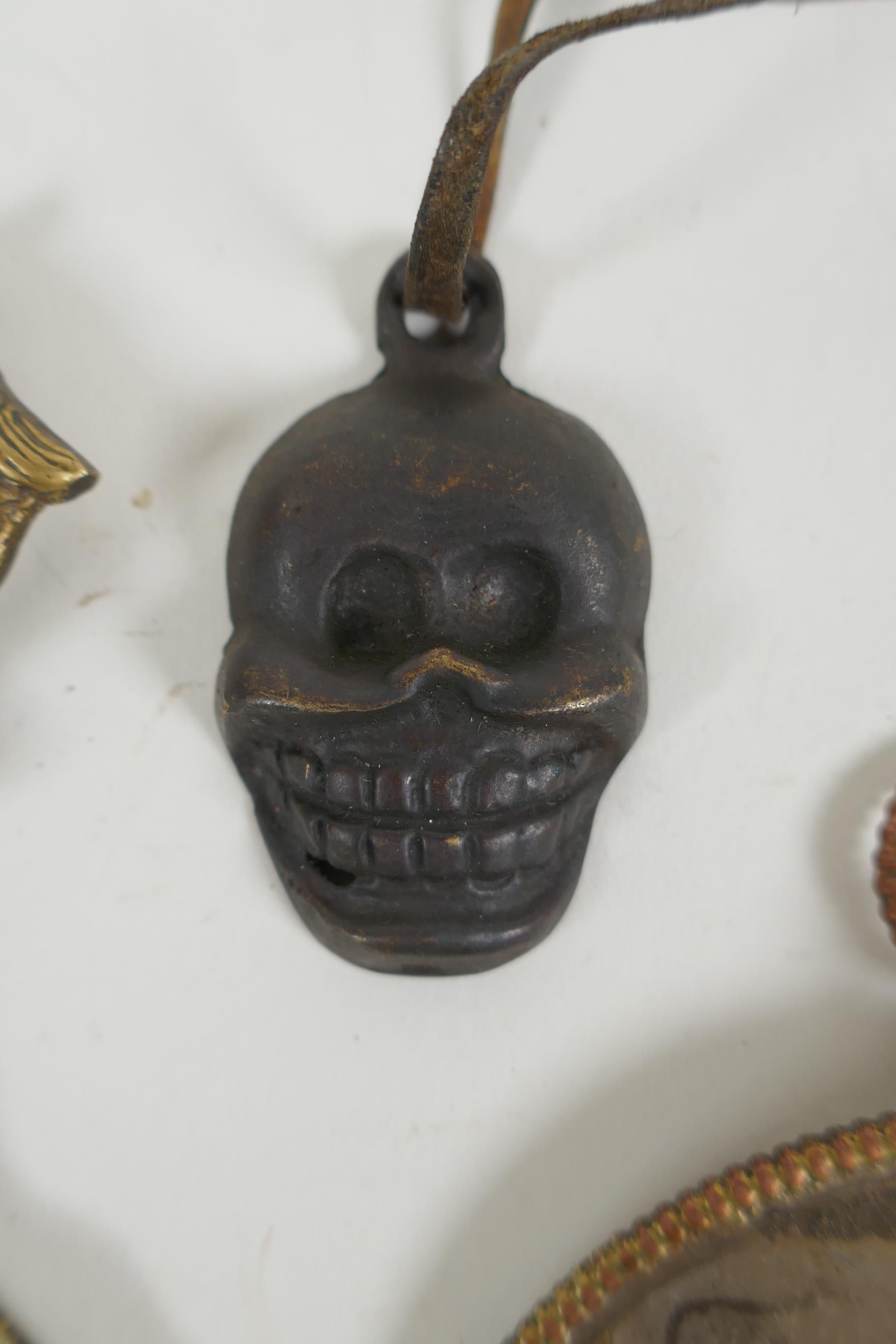 A Tibetan metal calendar, a convex mirror pendant and a cast iron skull pendant, 10cm diameter - Image 3 of 5