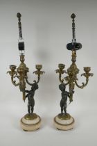 A pair of bronze and ormolu cherub three branch candlesticks converted to a lamp, 60cm high