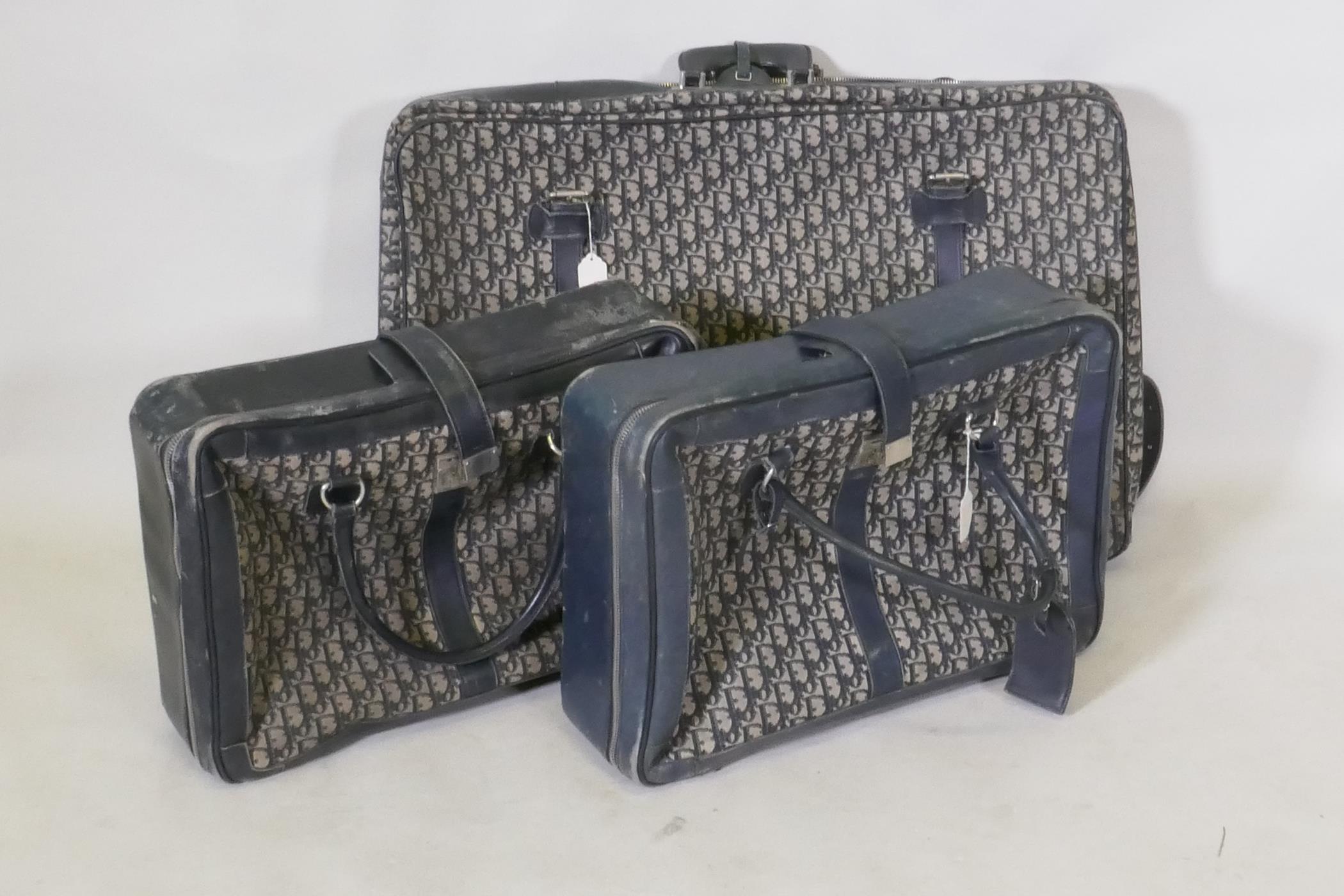 Christian Dior, three vintage fabric and blue leather suitcases, c.1970s, 75 x 50 x 15cm