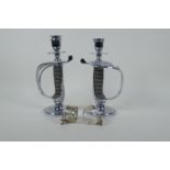 A pair of chromed Victorian sword hilt candlesticks with shagreen handles, and a pair of silver