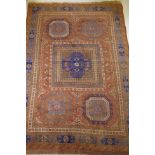 An antique Bergama carpet, with geometric designs on a terracotta coloured field and soft sheen to