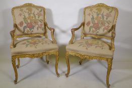 A pair of late C19th carved giltwood elbow chairs, labelled Bertram & Son, 100 and 101, Dean Street,