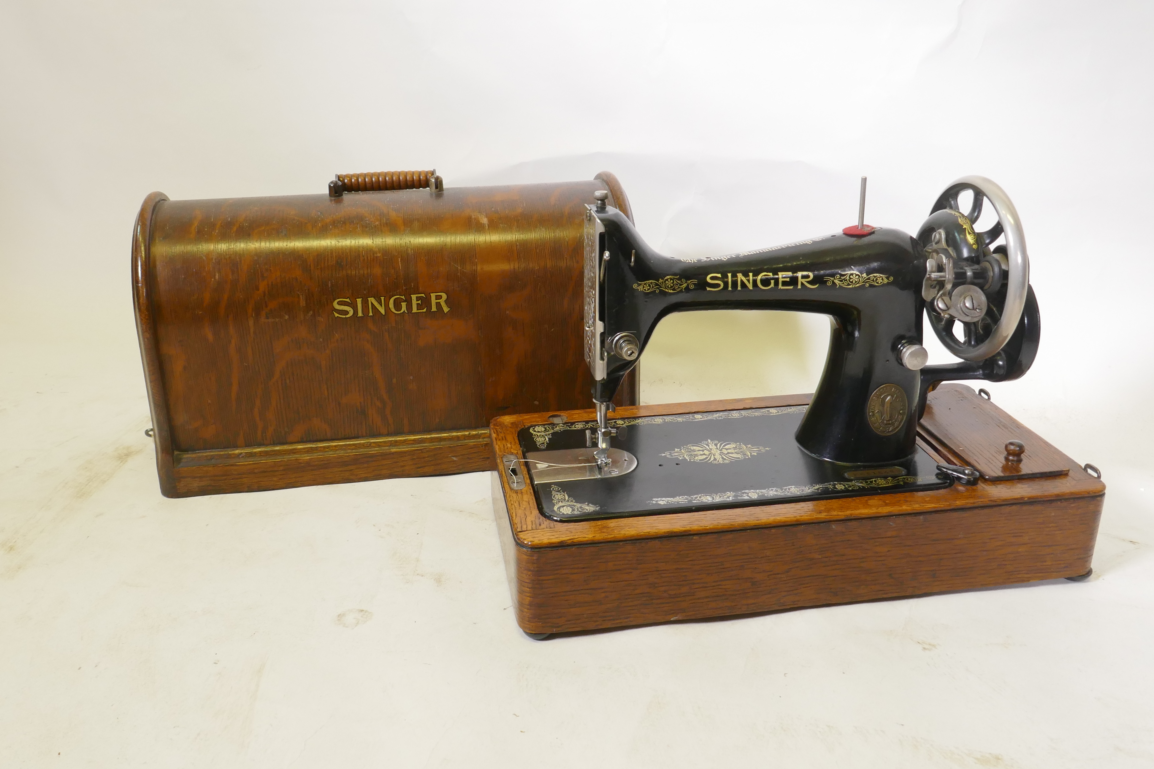 A Singer hand cranked sewing machine, No F6515489, in an oak case