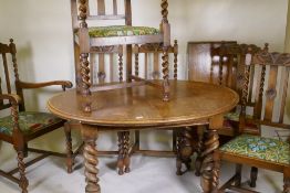 An early C20th oak wind out dining table, with extra leaf, raised on handed barley twist supports,