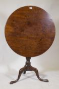 Georgian mahogany tilt top table, raised on a turned column and tripod supports with pad feet,