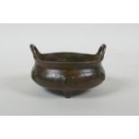 A Chinese bronze censer with two handles, character decoration and tripod supports, impress Xuande 6