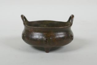 A Chinese bronze censer with two handles, character decoration and tripod supports, impress Xuande 6