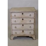 A painted pine chest of four long drawers with brass ring handles, raised on bracket supports, 61