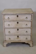 A painted pine chest of four long drawers with brass ring handles, raised on bracket supports, 61