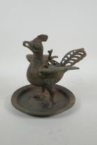 A Chinese archaic style bronzed metal censer in the form of a phoenix standing on a platter, 20cm