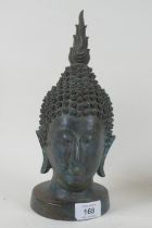 A vintage bronze Buddha's head, mounted on a metal stand, 27cm high