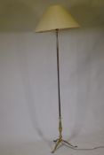 A vintage brass floor lamp raised on tripod supports, 150cm high