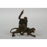 A Chinese bronze figure of Lohan riding a tiger, 7cm long