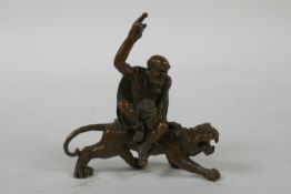 A Chinese bronze figure of Lohan riding a tiger, 7cm long