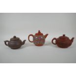 Three Chinese YiXing teapots, one with famille rose enamelled floral decoration, AF, largest 13cm