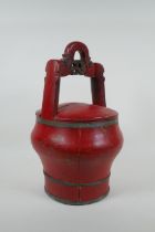 An antique Chinese red lacquered wood and metal bound wedding basket, 36cm high