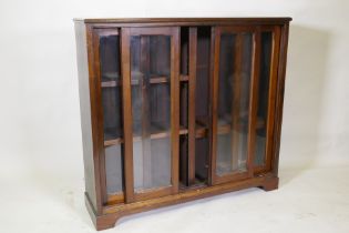 A mahogany bookcase with four sliding glass doors, 110 x 30 x 101cm