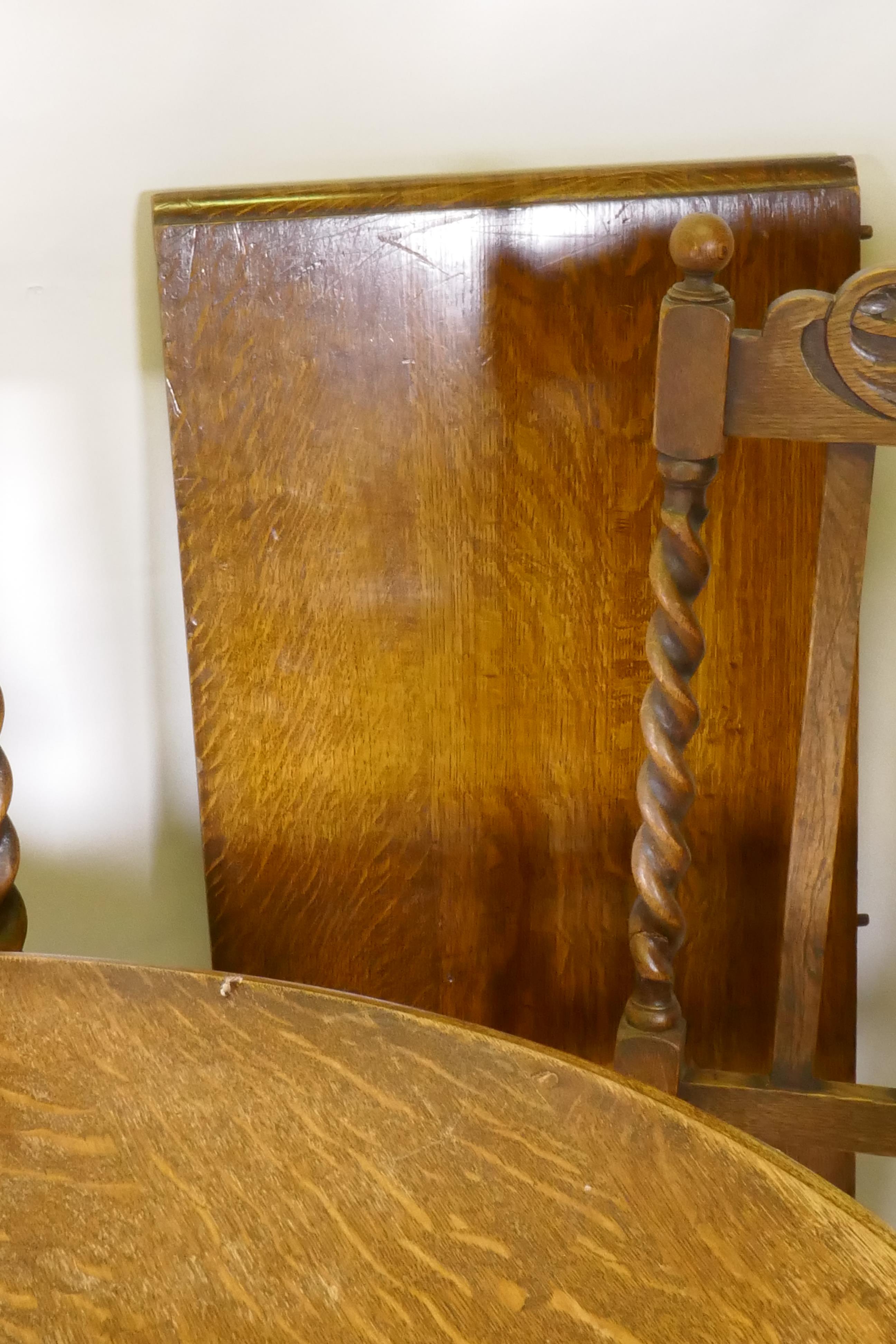 An early C20th oak wind out dining table, with extra leaf, raised on handed barley twist supports, - Image 6 of 7