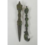 A Tibetan cast iron phurba with a wrathful deity mask handle, and a similar cast iron kartika,