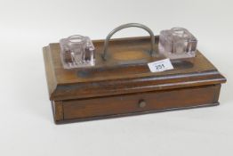 A mahogany desk stand with two glass inkwells and inlaid decoration, bears plaque, present to Miss
