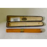 A Victorian amber cigar holder with 9ct gold mounts, cased with label Comoys London, 14cm long, AF