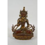 A Tibetan gilt bronzed metal figure of Buddha holding a vajra, 21cm high