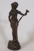 An Art Nouveau style bronze figure of a woman bearing a lily, inscribed Lola, 32cm high