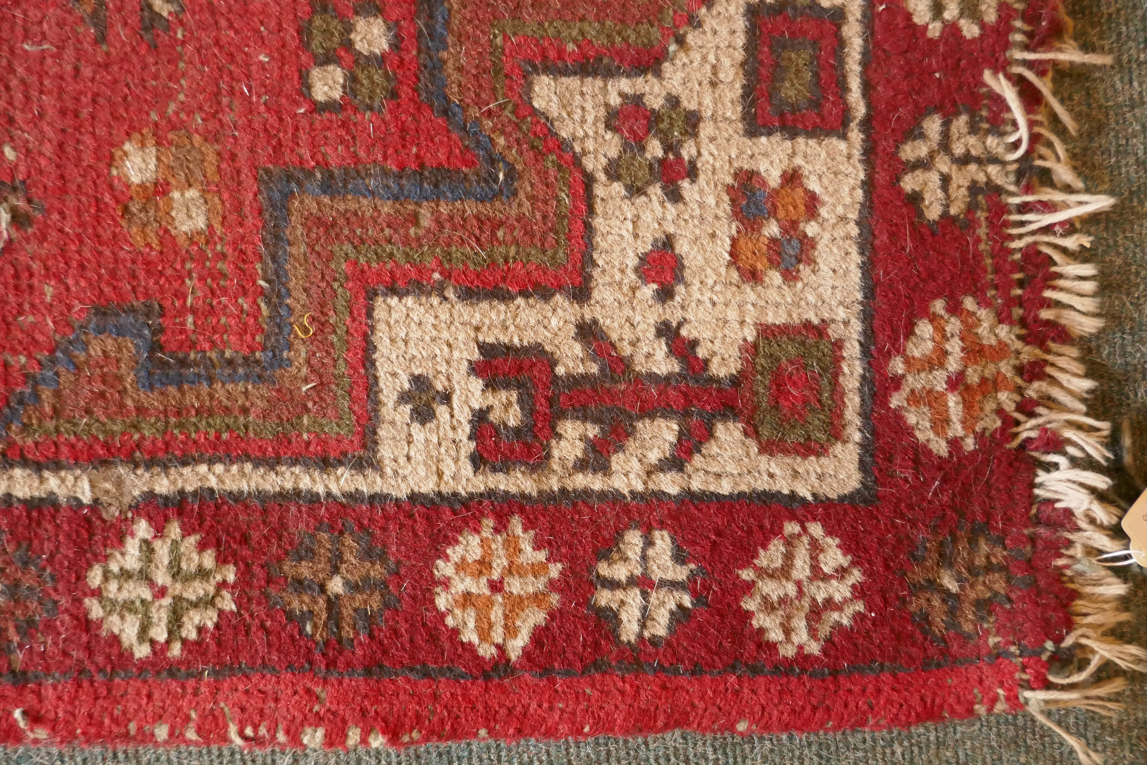 A Persian red ground wool rug with a geometric medallion design, 66 x 122cm - Image 2 of 3