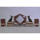 An Art Deco French rouge marble mantel clock garniture, with bronzed metal figures of Alsatian dogs,