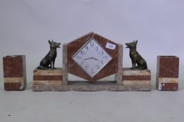 An Art Deco French rouge marble mantel clock garniture, with bronzed metal figures of Alsatian dogs,