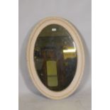 An antique painted wood and composition oval shaped wall mirror, 90 x 60cm