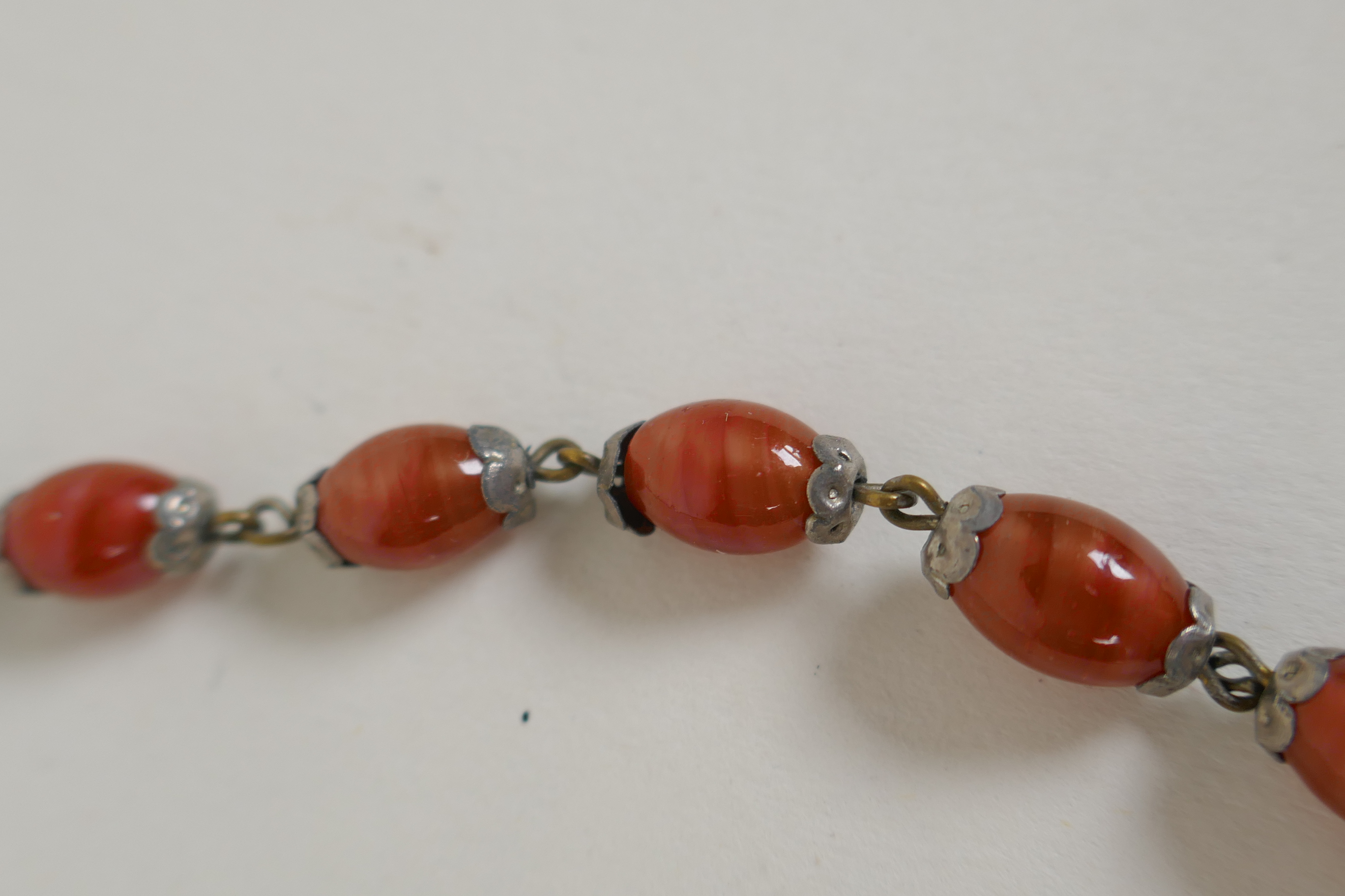 An antique graduated amber swirled glass necklace, 78cm long - Image 4 of 4