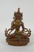 A Tibetan gilt bronzed metal figure of Buddha holding a vajra, 21cm high