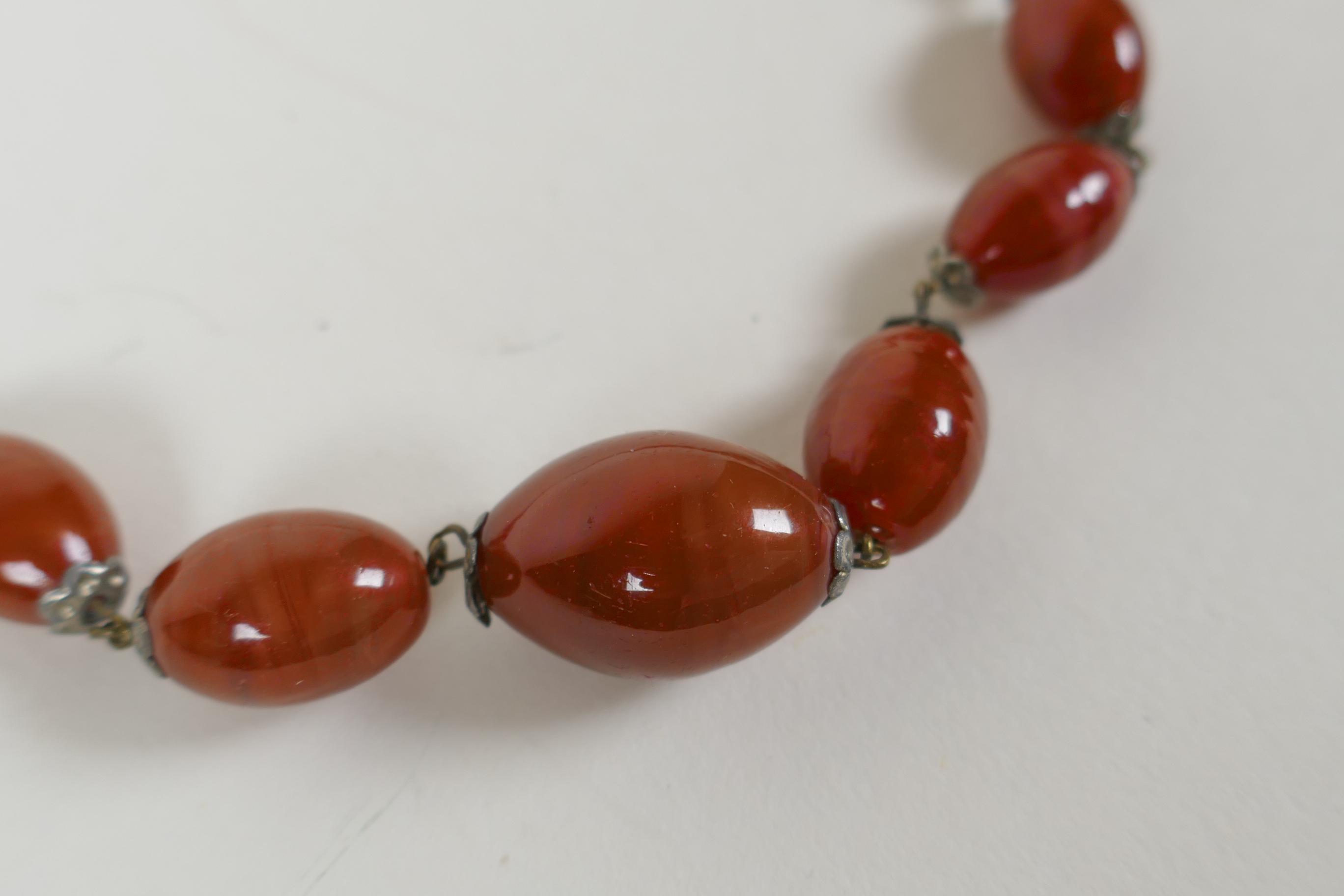 An antique graduated amber swirled glass necklace, 78cm long - Image 2 of 4